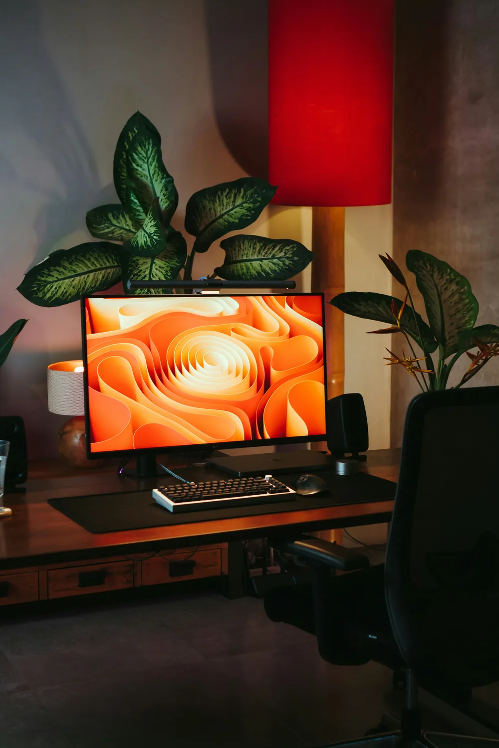 Designer's desk with a monitor showing an abstract orange graphic